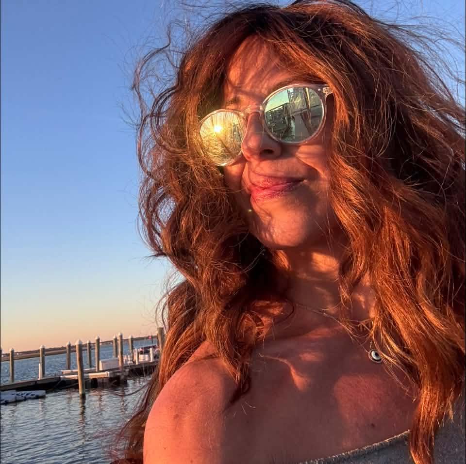 Sonia Lopez smiling in the golden-hour sun by the water